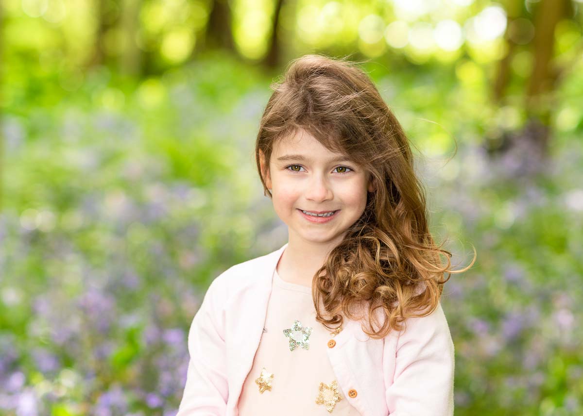 Little girl standing in a field of bluebells for her family photoshoot